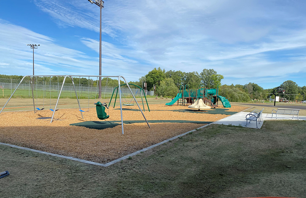 Beautiful green playground and swings with ADA pathways
