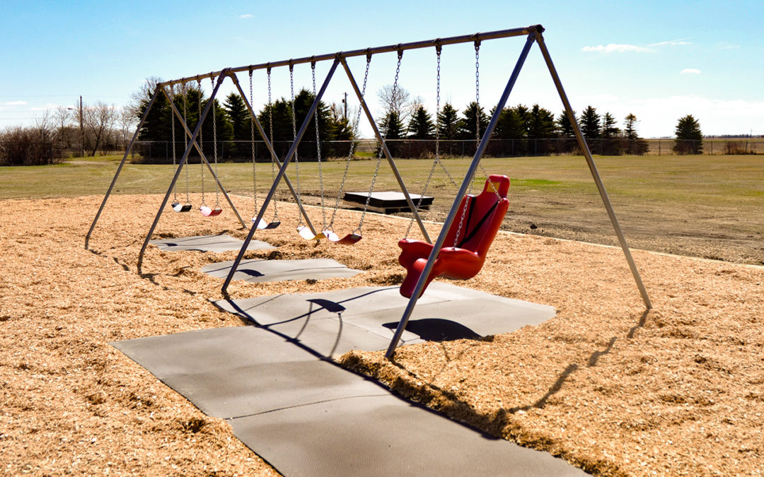 Outdoor swing set with rubber pathways leading to an accessible swing